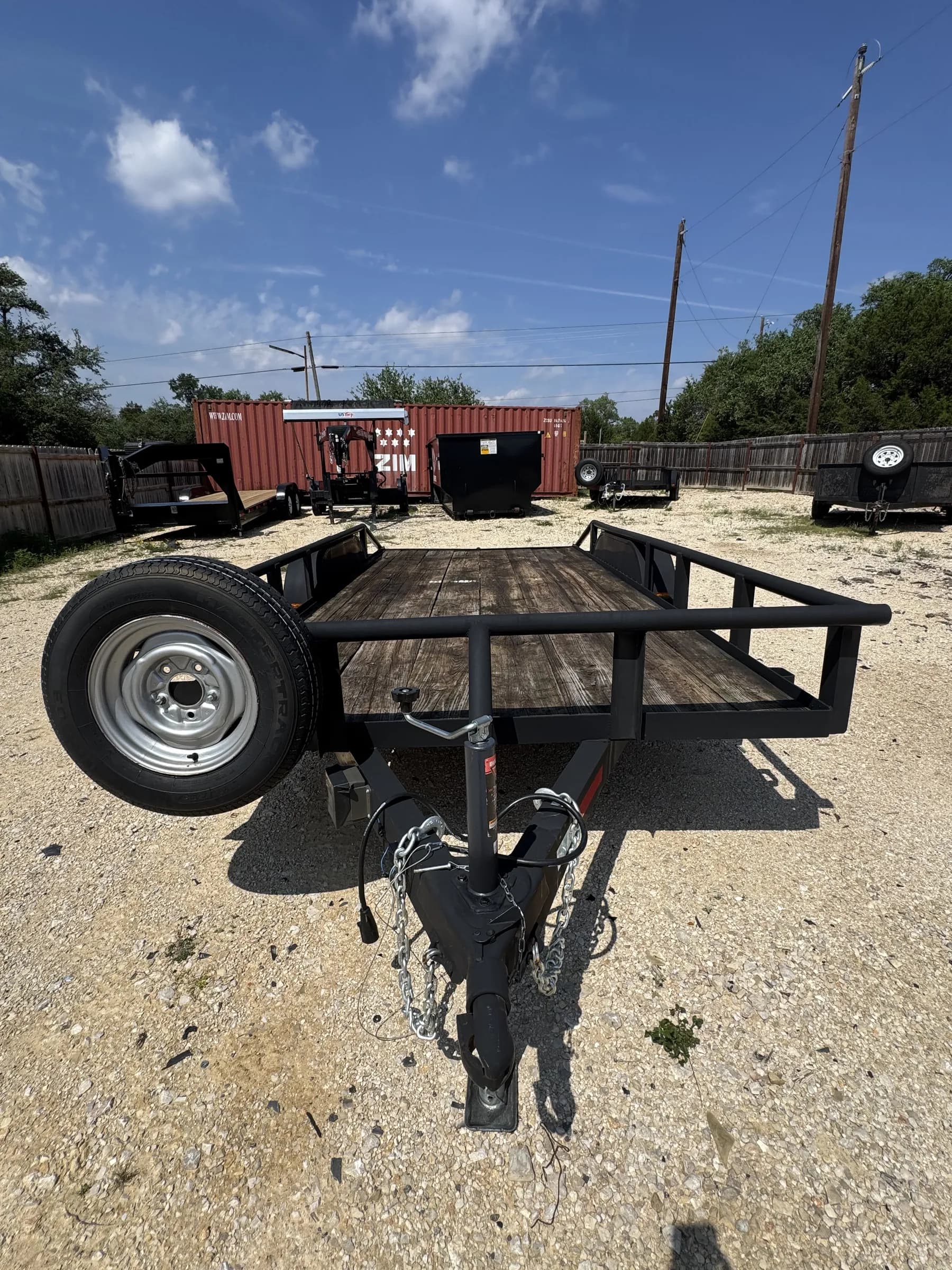 16-foot utility trailer with wooden deck and steel frame on the RedLine rental yard