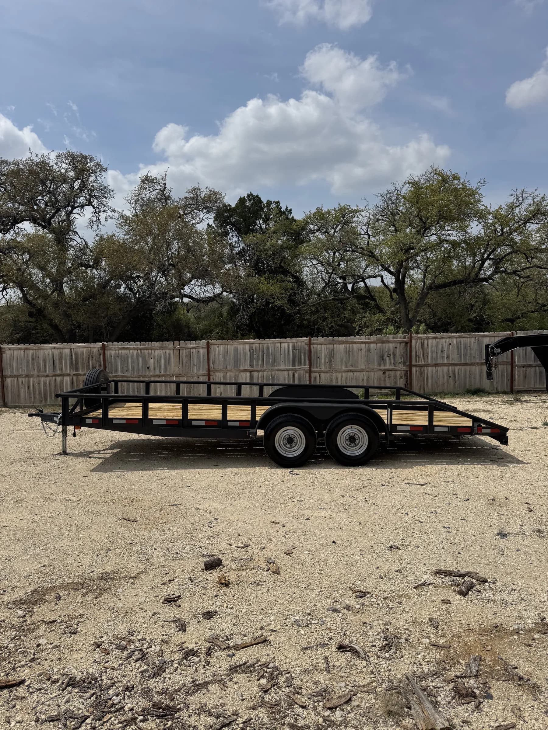 20-foot black utility trailer with wood deck on the RedLine rental lot, Texas Hill Country
