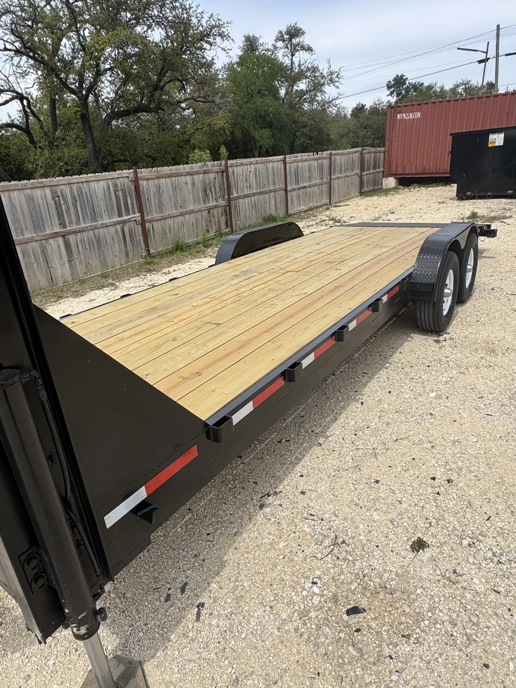 24-foot gooseneck flatbed trailer with wood deck at the RedLine rental yard