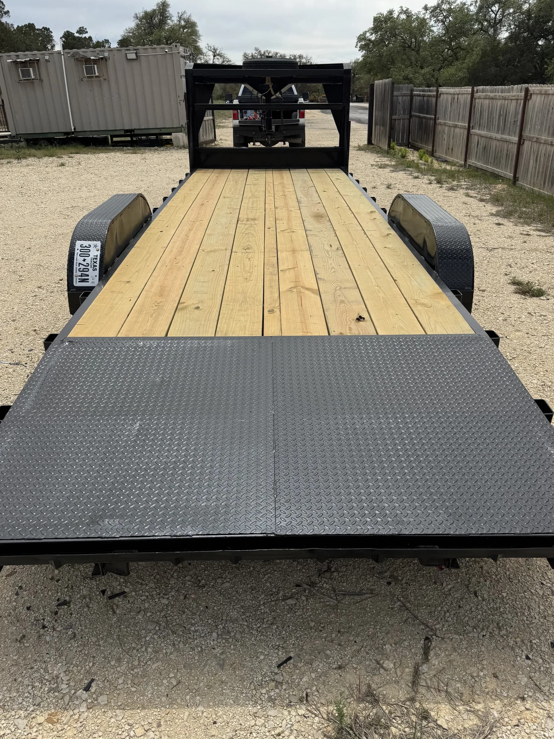 24-foot gooseneck trailer with wood deck and diamond plate steel ramps at the RedLine rental lot