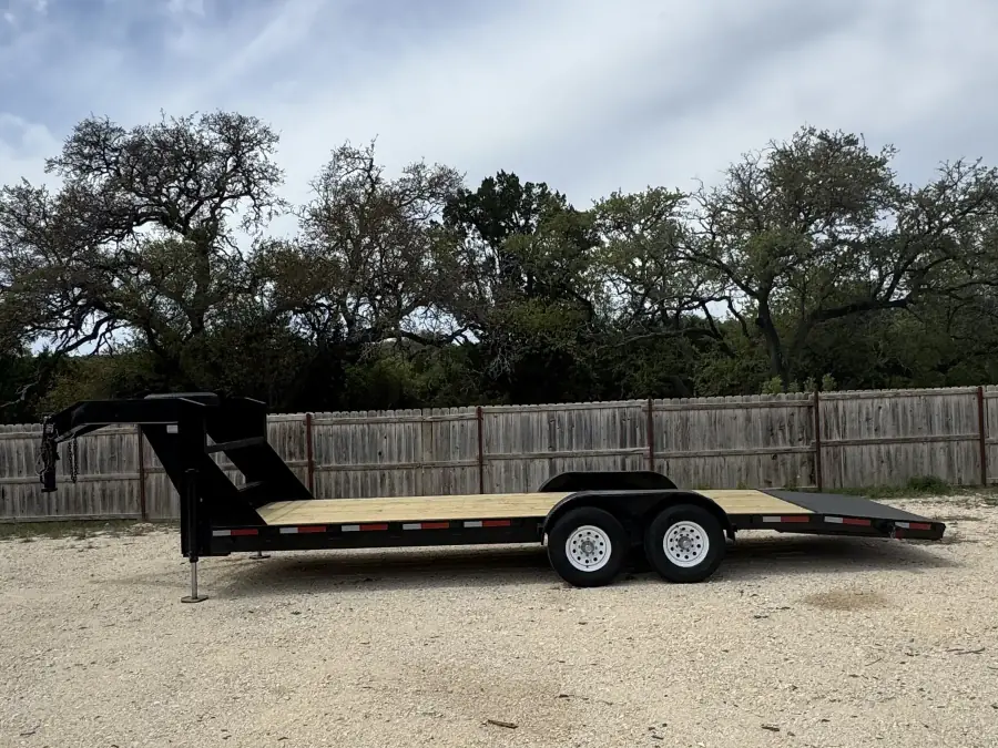 24-foot gooseneck trailer with wood deck on the gravel RedLine rental lot