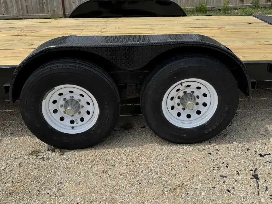 Dual axle wheels and wooden deck close-up on the RedLine 24-foot gooseneck trailer