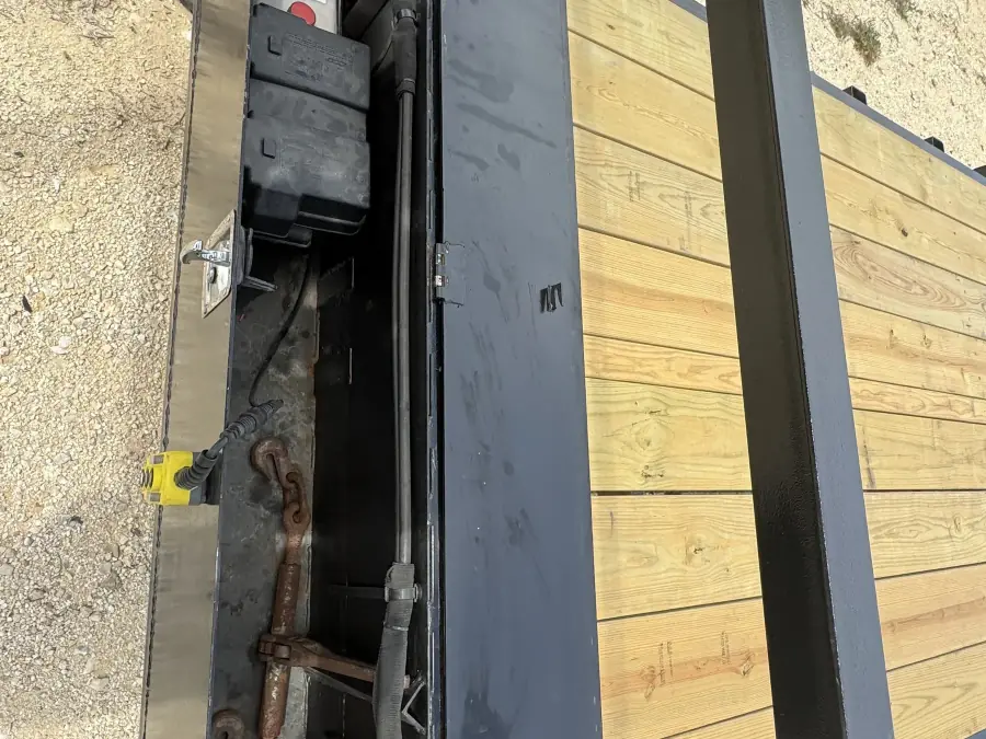 Open storage compartment showing hydraulic system and chains on the RedLine 24-foot gooseneck